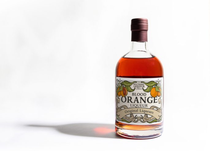 A bottle of Blood Orange Liqueur from the Wiltshire Liqueur Company, on a white background.