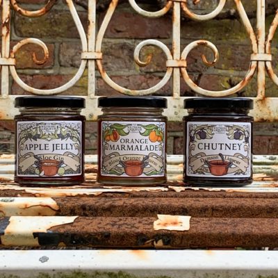 A picture of three of The Wiltshire Liqueur Company's preserves. From left to right: Sloe Gin Apple Jelly, Blood Orange Liqueur Marmalade, and Damson Liqueur Chutney.